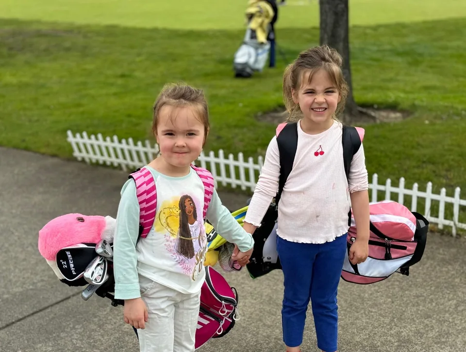 Young golfers with their golf bags.
