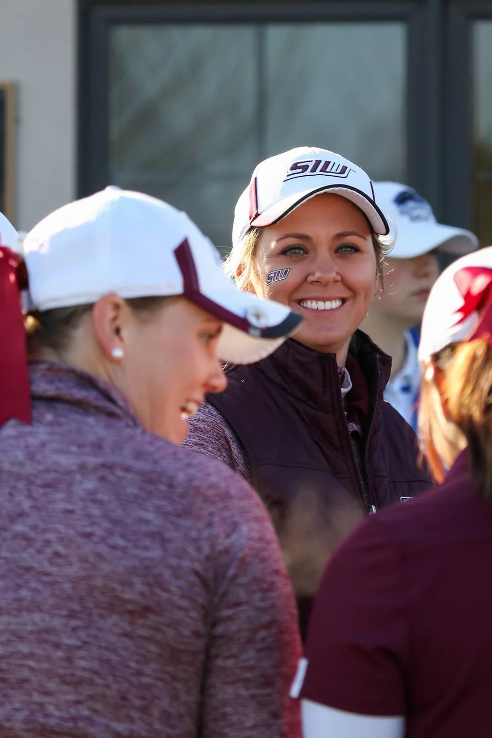 A coach talking with golfers during collegiate competition.